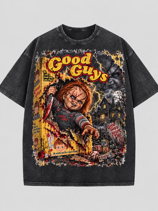 Washed dark T-shirt featuring Chucky emerging from a toy box beneath yellow and red “Good Guys” lettering, with lightning and a dark house.