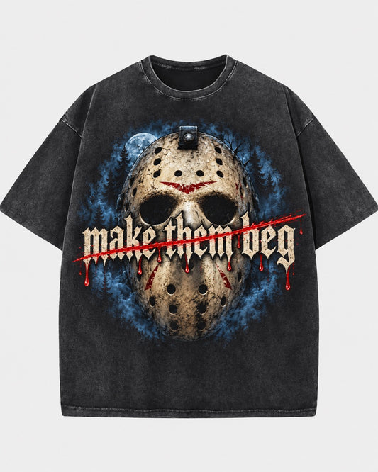Front of a washed dark T-shirt featuring a hockey mask, blue forest scene, and “Make Them Beg” lettering with a red slash.
